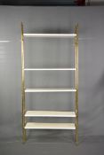 A BRASS ADJUSTABLE WALL SHELVING SYSTEM, comprising of four brass tubular uprights and fourteen
