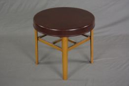 A BAKELITE CIRCULAR OCCASIONAL TABLE, the burgundy bakelite top supported on four domed metal legs