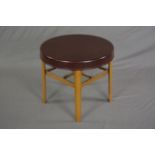 A BAKELITE CIRCULAR OCCASIONAL TABLE, the burgundy bakelite top supported on four domed metal legs