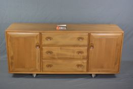 AN ERCOL WINDSOR ELM SIDEBOARD, with three long drawers and two cupboard doors on casters,