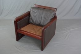 A DYRLUND DANISH ARMCHAIR, rosewood finish, with brown leather back and sides (missing one cushion)