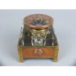 AN ARTS & CRAFTS STYLE SQUARE GLASS INKWELL, hinged circular copper cover with cast foliate motif