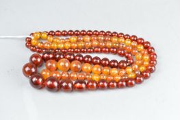 TWO STRINGS OF AMBER TYPE BEADS, comprising round graduated beads (2)