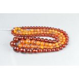 TWO STRINGS OF AMBER TYPE BEADS, comprising round graduated beads (2)