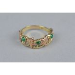 A CLOGAU EMERALD ROSE AND YELLOW METAL RING, the stylised openwork vine leaf design hand set with