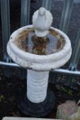A COMPOSITE BIRD BATH, with central column and a dove figure on the top, approximate height 98cm (3)