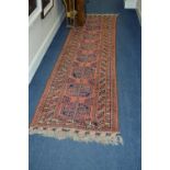A 20TH CENTURY AFGHAN CARPET RUNNER, russet ground, multi strap border and central geometric motifs,