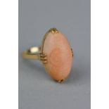 A SINGLE STONE OVAL CABOCHON CUT CORAL RING, coral measuring approximately 21mm x 12mm, ring size