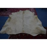 A CHAROLAIS COW HIDE RUG, inscribed verso, that it came from the First Charolias Calf to be born