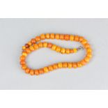 A STRING OF GRADUATED COPAL AMBER TYPE BEADS, approximate length 37cm, approximate gross weight 23.5