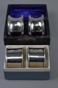 TWO CASED PAIRS OF SILVER NAPKIN RINGS