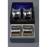 TWO CASED PAIRS OF SILVER NAPKIN RINGS