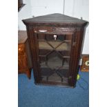 AN EARLY 20TH CENTURY CARVED OAK ASTRAGAL GLAZED HANGING CORNER CUPBOARD