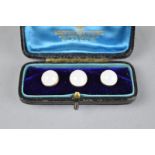 A CASED SET OF THREE EARLY 20TH CENTURY MOONSTONE YELLOW METAL DRESS STUDS, the circular cabochon
