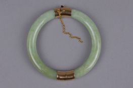 A MODERN JADE BANGLE, round hinged design with two pale green jadeite hooped sections, each capped