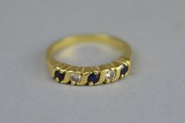 A SAPPHIRE AND DIAMOND FIVE STONE 18CT YELLOW GOLD RING, alternate small round mixed cut sapphires