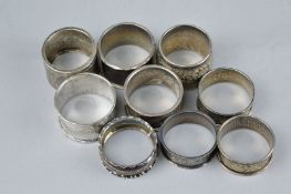 SEVEN SILVER NAPKIN RINGS, approximate weight 93.3 grams, together with two white metal napkin