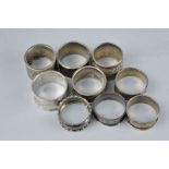 SEVEN SILVER NAPKIN RINGS, approximate weight 93.3 grams, together with two white metal napkin