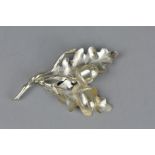 A SILVER ACORN BROOCH IN THE FORM OF TWO LEAVES AND TWO ACORNS, approximate length 9cm,