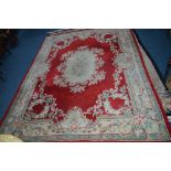 A WOOLLEN CARPET SQUARE, red and cream ground, floral decoration, multi strap border and central