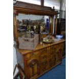 AN ARTS AND CRAFTS CARVED OAK MIRROR BACK SIDEBOARD, the upper section with carved gallery to two