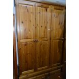 A TALL PINE THREE DOOR WARDROBE, above two various drawers, approximate size width 138cm x height