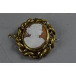 A VICTORIAN CAMEO BROOCH, carved shell cameo with a maiden in profile, with swivel hair locket to