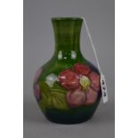 A SMALL MOORCROFT POTTERY VASE, 'Clematis' pattern on green ground, impressed marks to base,