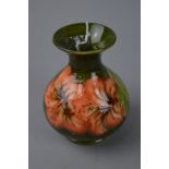 A SMALL MOORCROFT POTTERY VASE, 'Hibiscus' pattern on green ground, impressed marks and paper