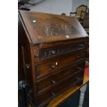 A CARVED OAK FALL FRONT BUREAU, with four drawers below