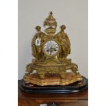 A LATE 19TH CENTURY GILT METAL MANTEL CLOCK, urn shaped finial with painted porcelain centre above