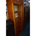 A YEW WOOD MODERN STANDING BOOKCASE, and four pictures including one of a sampler (5)