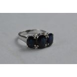A WHITE METAL THREE SAPPHIRES AND DIAMOND RING, ring size M, approximate weight 4.9 grams