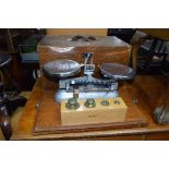 A CASED BALANCE SCALES, by J W Towers & Co Ltd, Widnes and a set of four weights (sd)