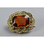 AN EARLY 20TH CENTURY CITRINE, DEMANTOID GARNET AND SEED PEARL BROOCH, rectangular shape with