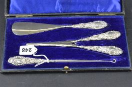 AN EDWARDIAN SILVER HANDLED SET OF BUTTON HOOK, SHOE HORN AND GLOVE STRETCHERS, makers Ceispin &