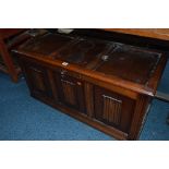 AN OAK LINEN FOLD BLANKET CHEST, (key) and a painted metal framed two tier tea trolley (2)