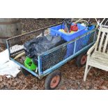 A METAL LAWNMOWER TRAILER, on four wheels with mesh stiles and contents