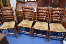 A SET OF FOUR OAK RUSH SEAT LADDERBACK CHAIRS, and a footstool (5)