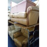A TAN LEATHER TWO PIECE SUITE, comprising of a three seater settee and an armchair