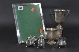 A SILVER FRAME, 17.5cm x 22.5cm, Birmingham 1962, together with a silver cup, mug and three piece