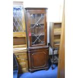 A MODERN MAHOGANY GLAZED CORNER CUPBOARD, an oak tea trolley and an open bookcase (3)