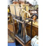 A STAINED OAK STICK STAND, with metal insert, containing a quantity of walking sticks including