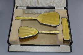 A YELLOW ENAMEL AND SILVER THREE PIECE DRESSING SET, boxed