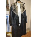 A LADIES BLACK LEATHER BELTED LONG COAT, with fur trim, 'Suede Centre' label