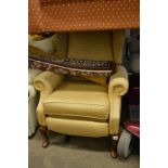 A GOLD UPHOLSTERED RECLINING ARMCHAIR