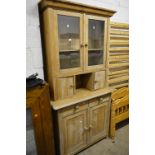 AN EARLY 20TH CENTURY PINE GLAZED TWO DOOR BOOKCASE, above two short drawers and double cupboard