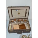 A TRAVELLING VANITY CASE, with enamelled top bottles/brushes and cigar case, Reg 3217