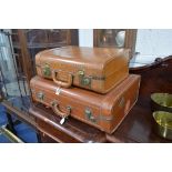 A SET OF TWO GRADUATING TAN LEATHER SUITCASES, Cornell label attached A.W.E. Stamped to each