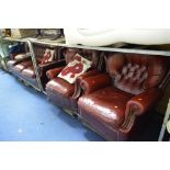 AN OX BLOOD LEATHER BUTTON BACK THREE PIECE SUITE, comprising of a three seater settee and a pair of